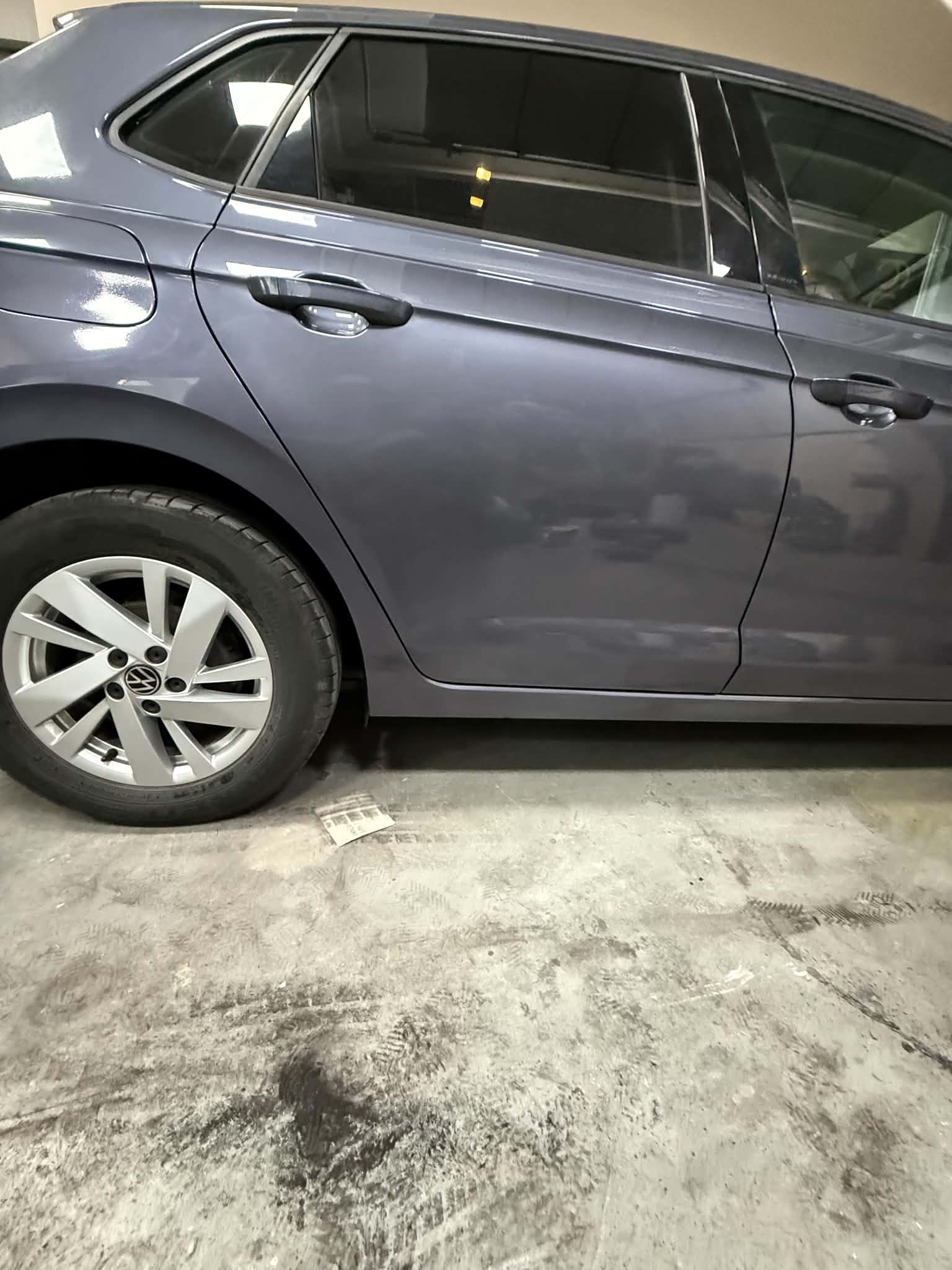 The same grey hatchback in the workshop with its doors repaired